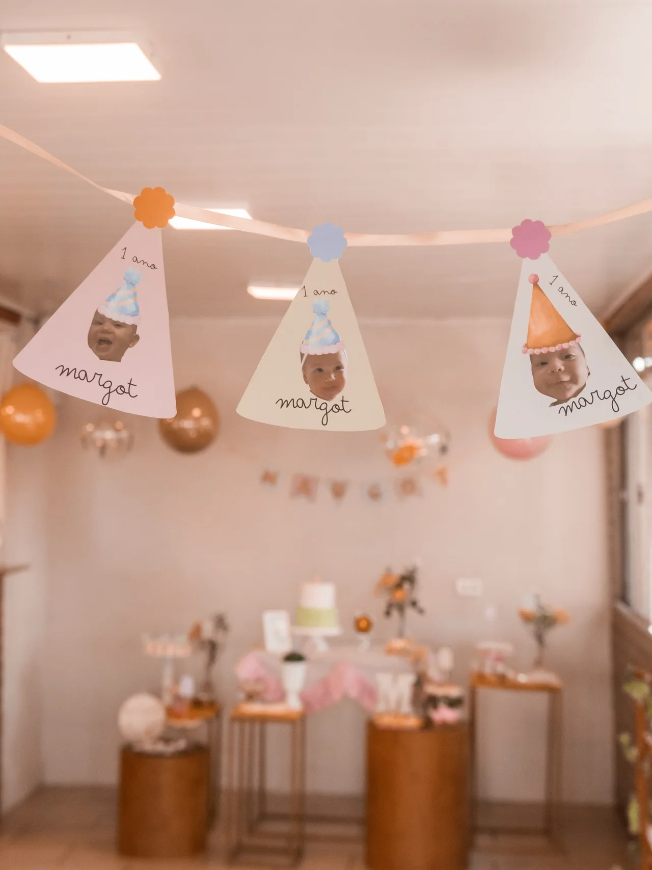 Bandeirolas personalizadas com fotos da criança na decoração de aniversário infantil.