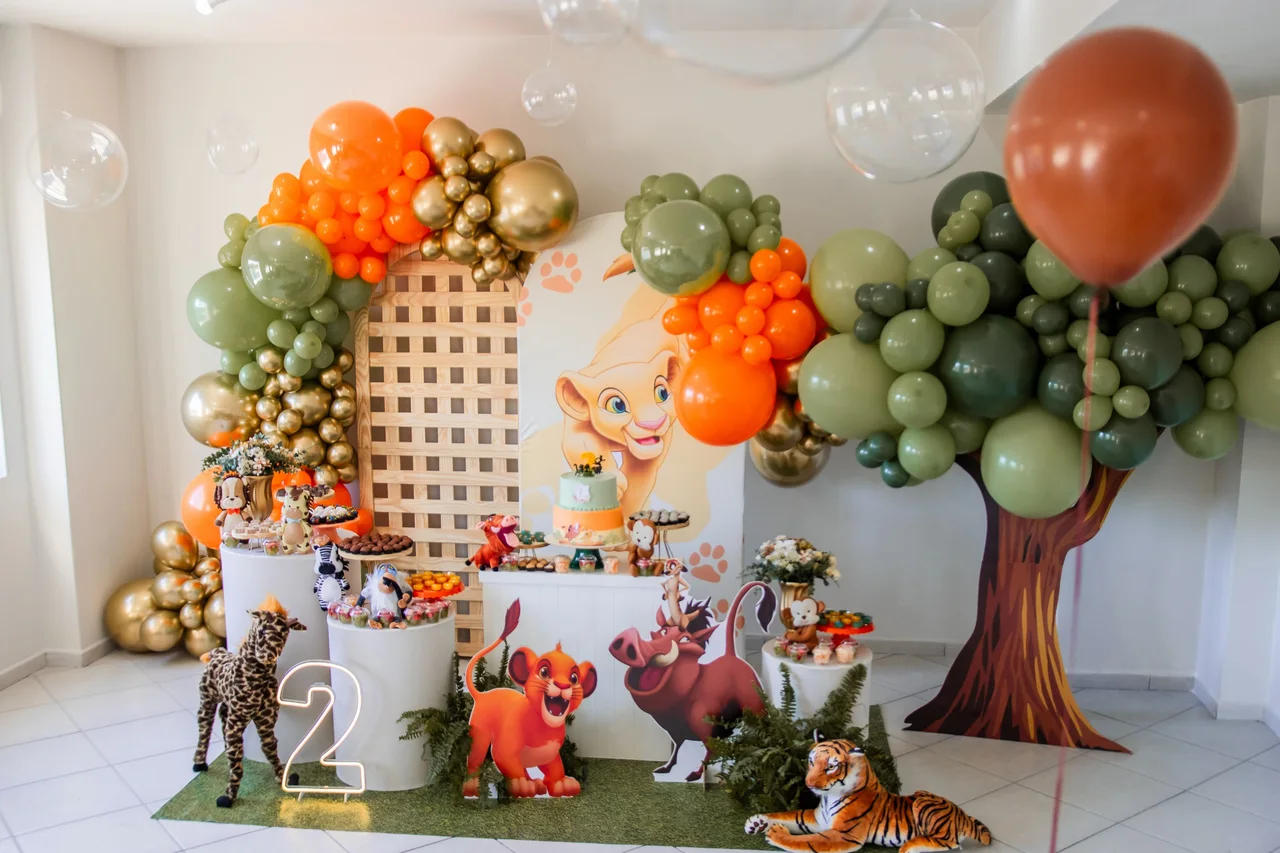 Decoração de aniversário infantil com balões, bolo e animais.