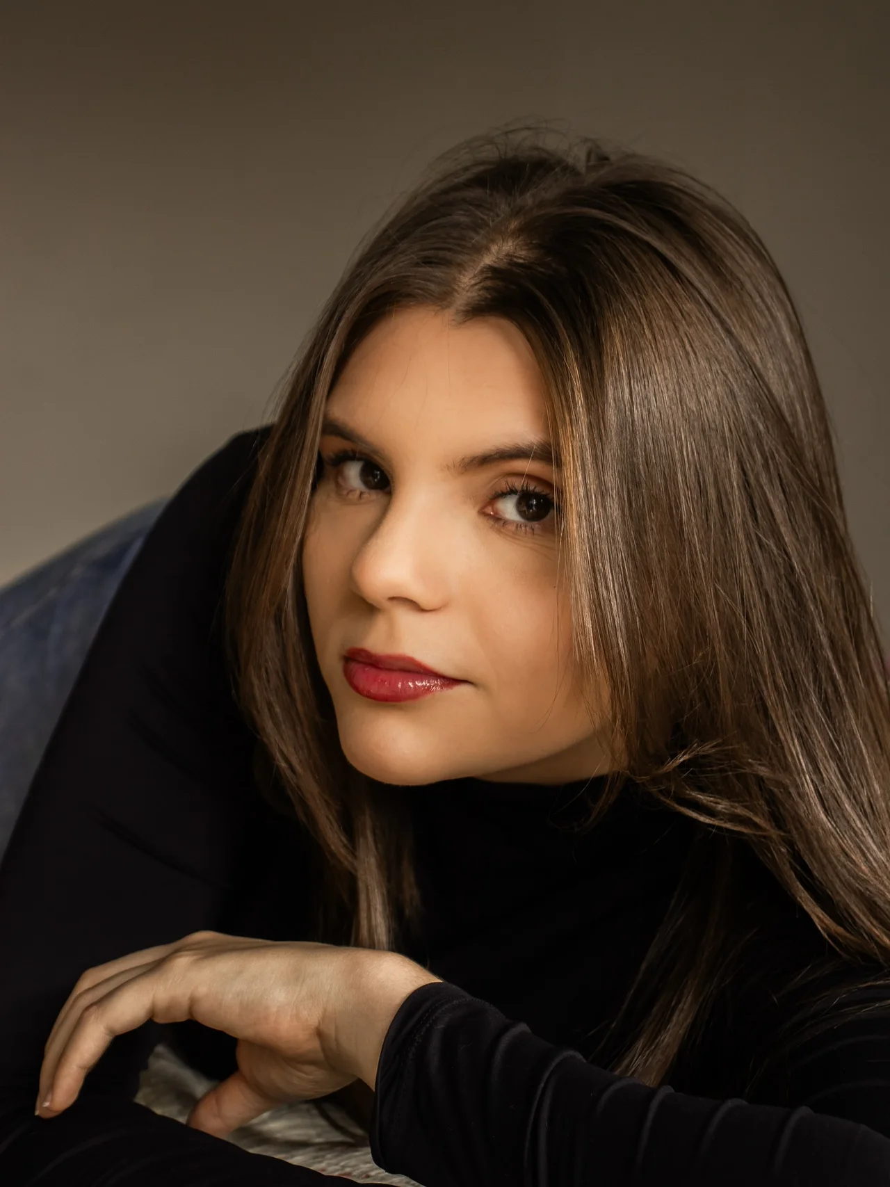 Heloize Piovezan, fundadora e fotógrafa, em retrato com roupa preta.